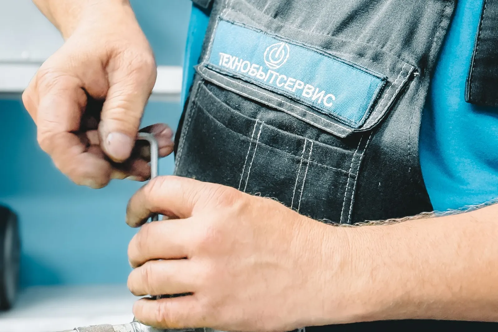 A plumber tightens a pipe with a wrench